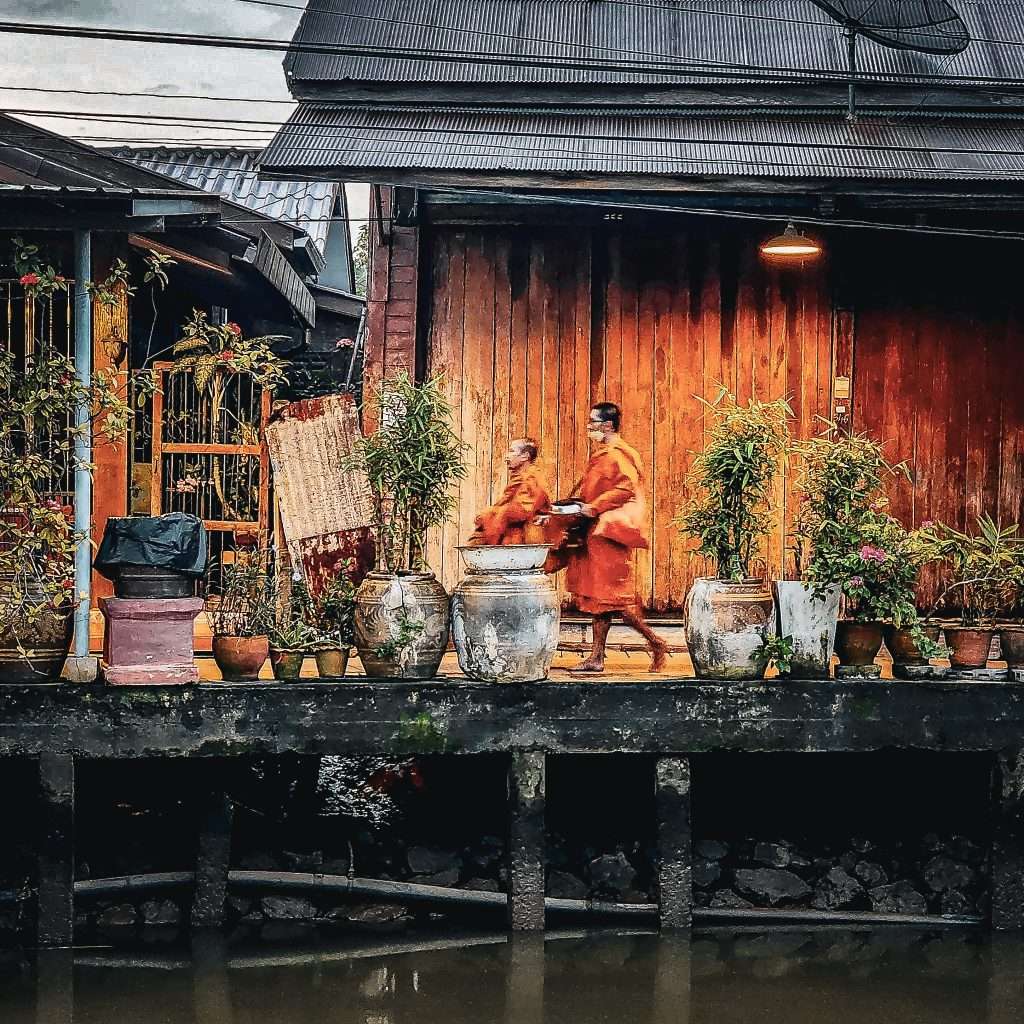 deux moines fesant la tournée des offrandes a travers les rues d'amphawa en thailande