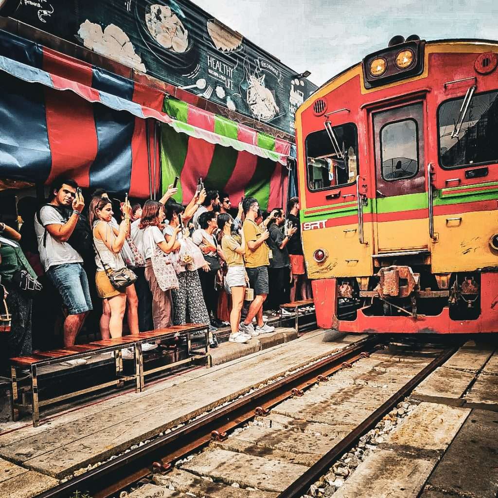 foule photographiant le train passant au milieux du marche de mae klongs