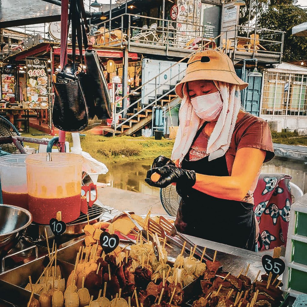 vendeuse de brochette au travail derriere son stand au chillva night market de phuket town