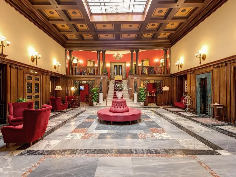 hall d'accueil au charme rococo fauteuil en velour rouge et marbre de l'hotel villa politi a syracuse