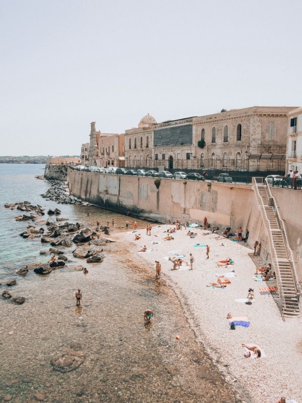 baigneur et touristes sur le sable de la plage de syracuse en sicile
