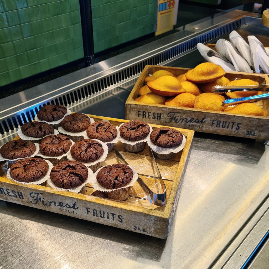 assortiment de muffins au chocolat et madeleines nature dans des plateaux en bois