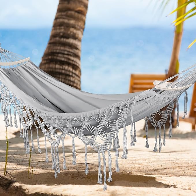 hamac blanc posé en bord de plage entre deux palmiers