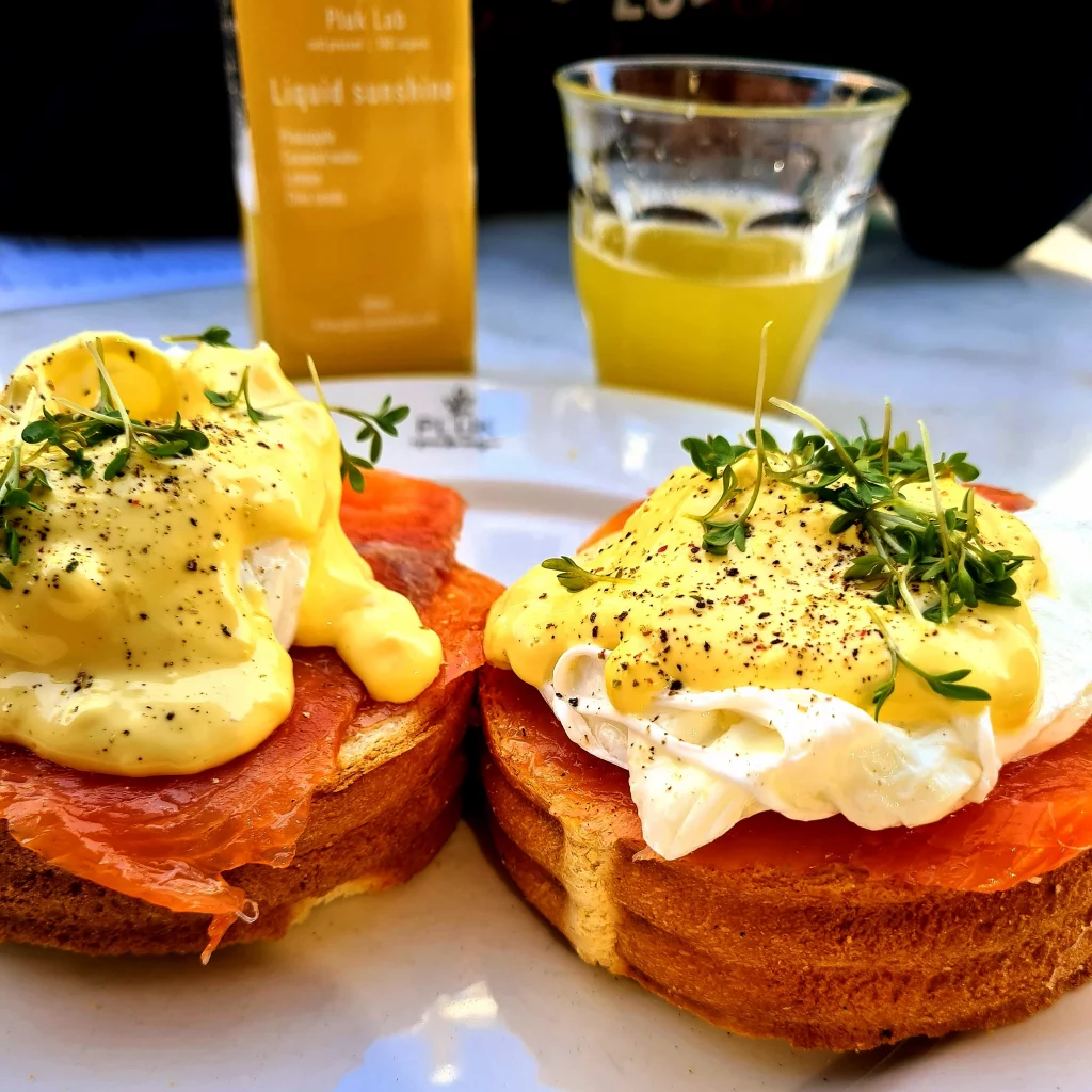 oeufs benedictes et jus d'orange servi sur la terrasse du restaurant pluk amsterdam