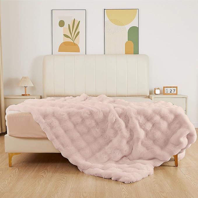 plaid rose cocooning matiere douce posé sur un lit