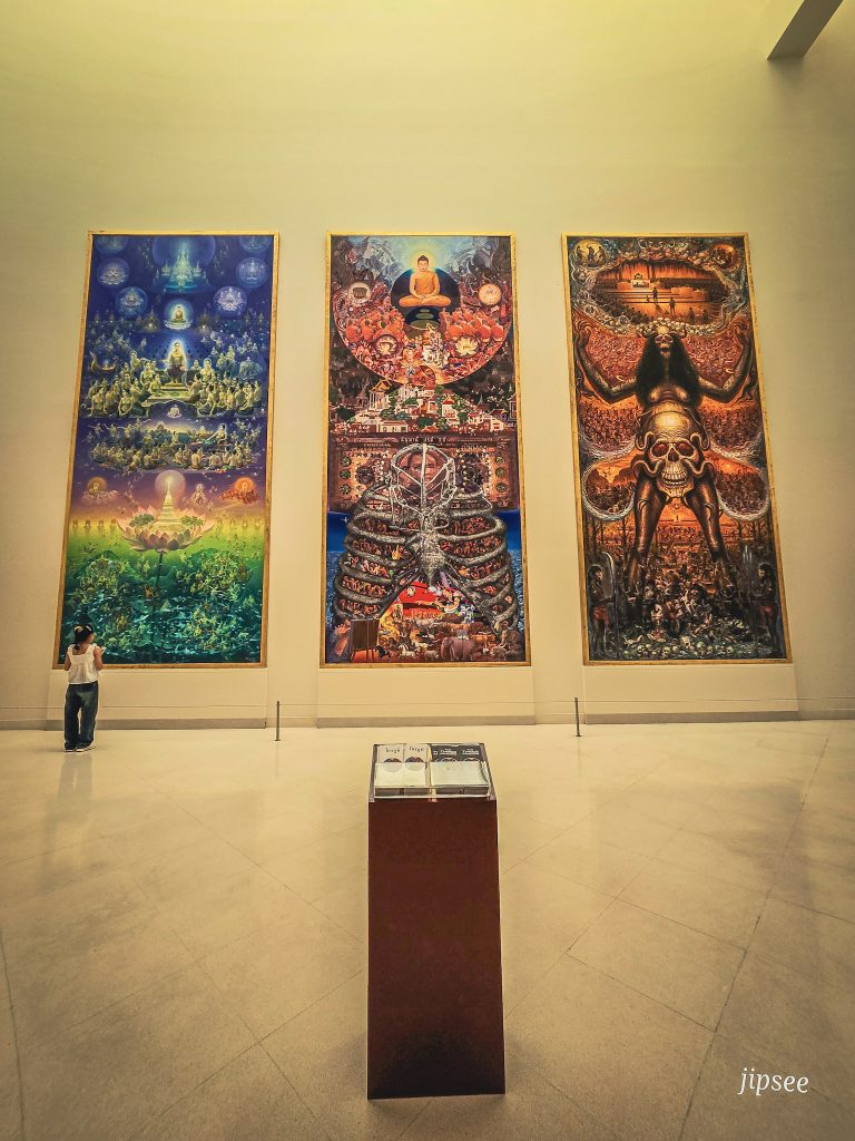 femme de dos devant un triptyque géant oeuvre d'art du moca museul de bagkok