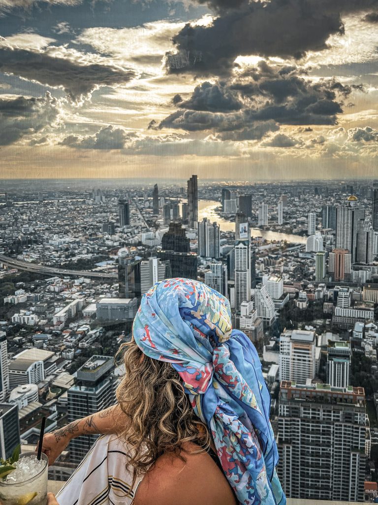 skyline de bangkok au sunset femme de dos au sommet de la mahanakhon tower