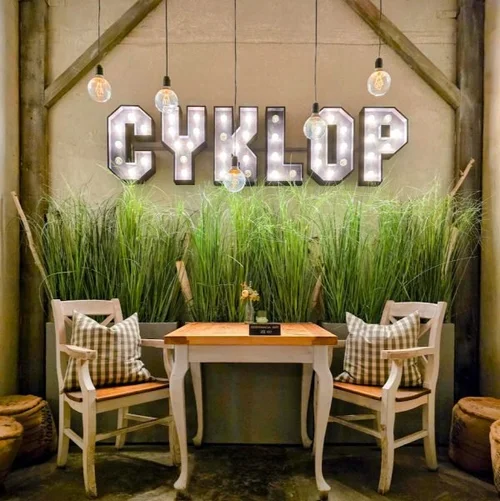 table de restaurant avec enseigne cyclop sur le mur arriere