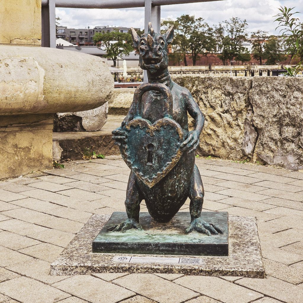 statue de dragon embleme de cracovie tenant un cadena a l'entree du pont des acrobates