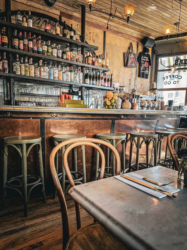 bar retro assortiment de bouteille et table de restaurant dressée