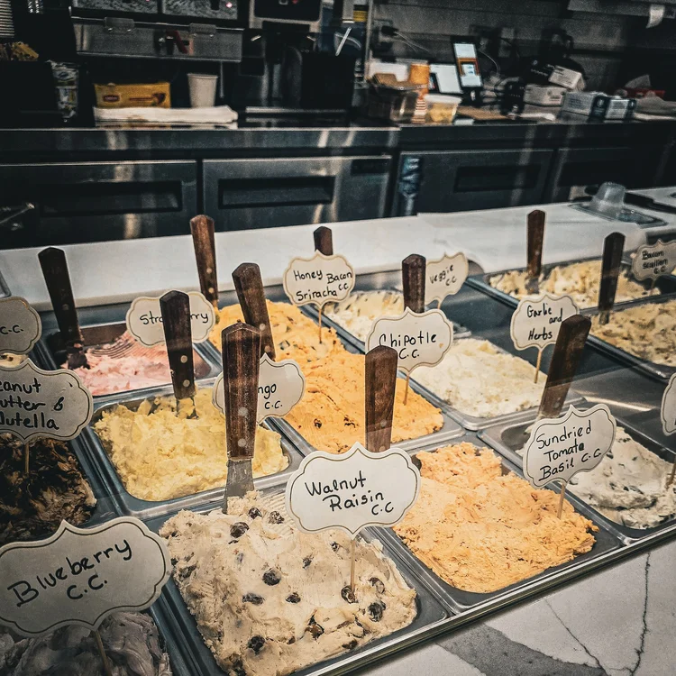 assortiment de differents gouts de cottage cheese sucrés et salés présentés dans une vitrine