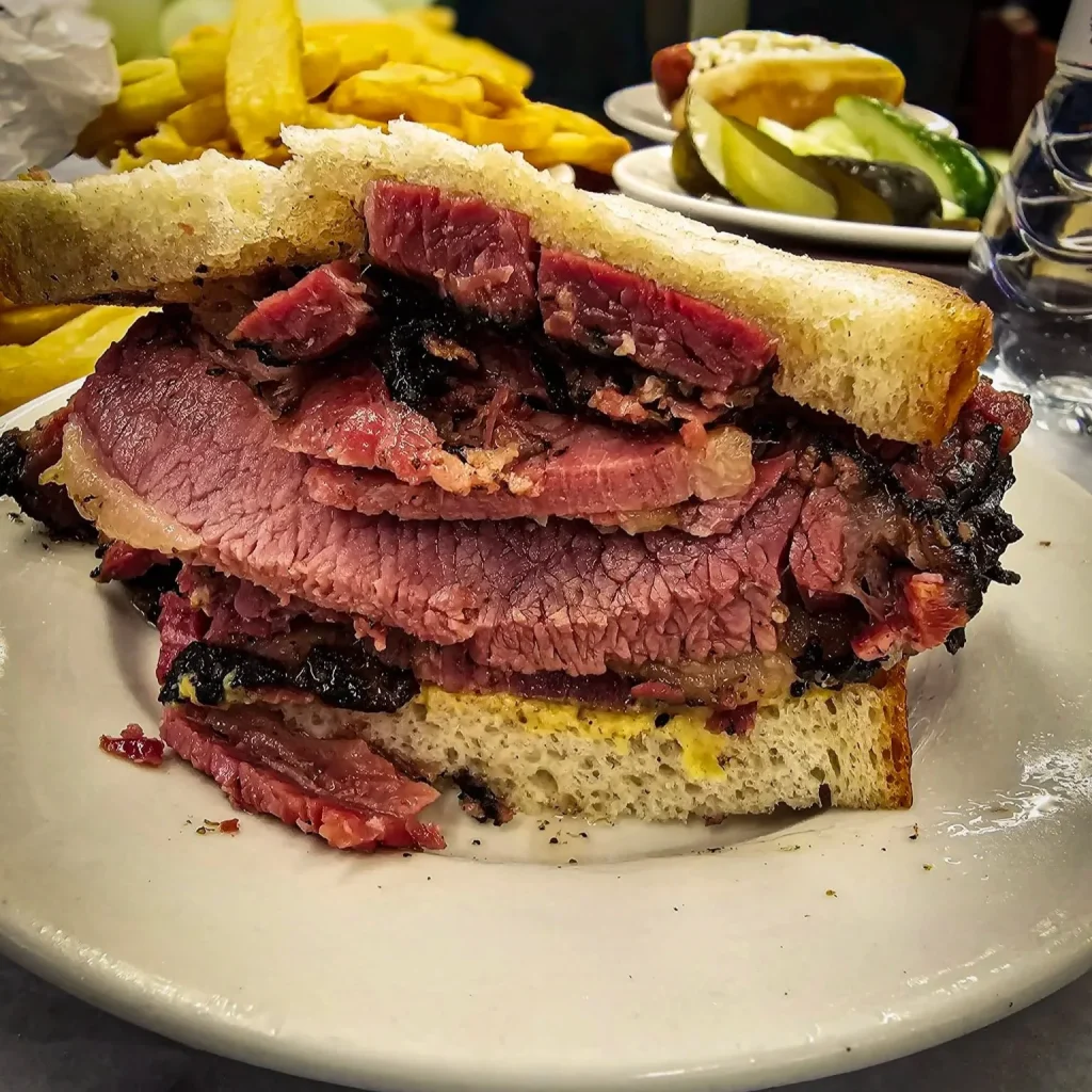 sandwich au pastrami viande et frites en arriere plan 
