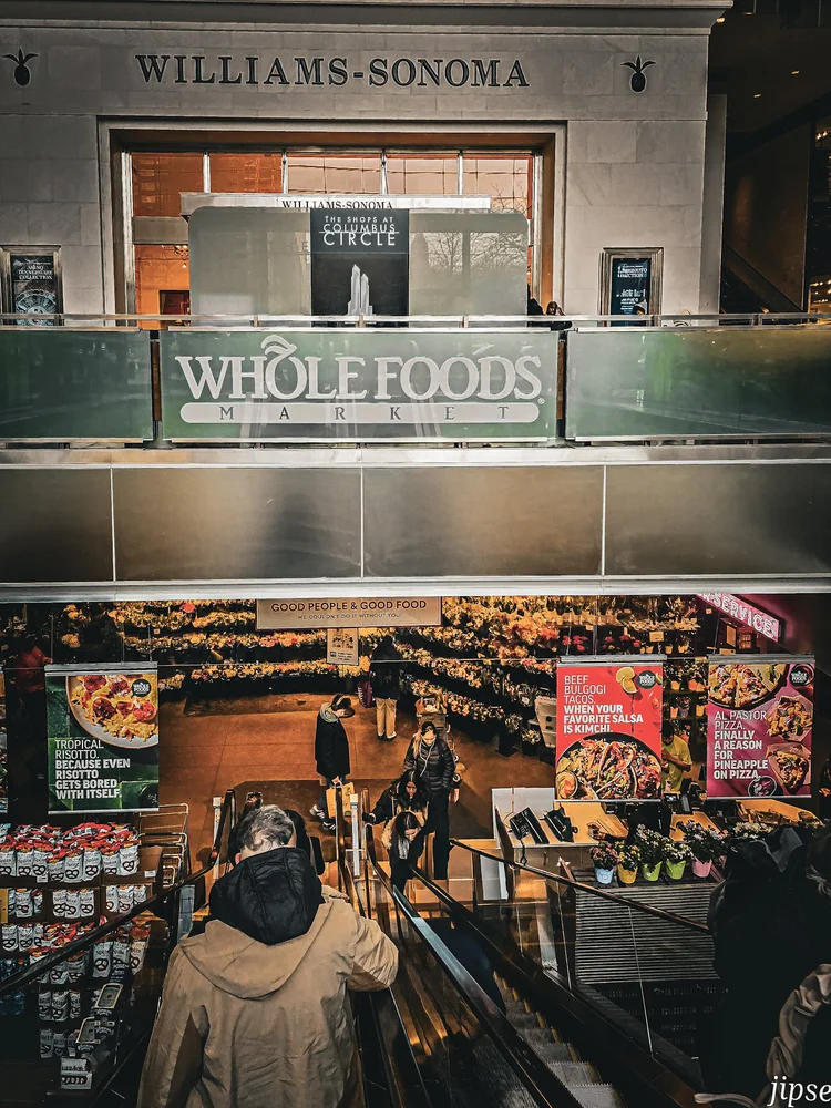 homme dans un escalator entrée du wholefood market