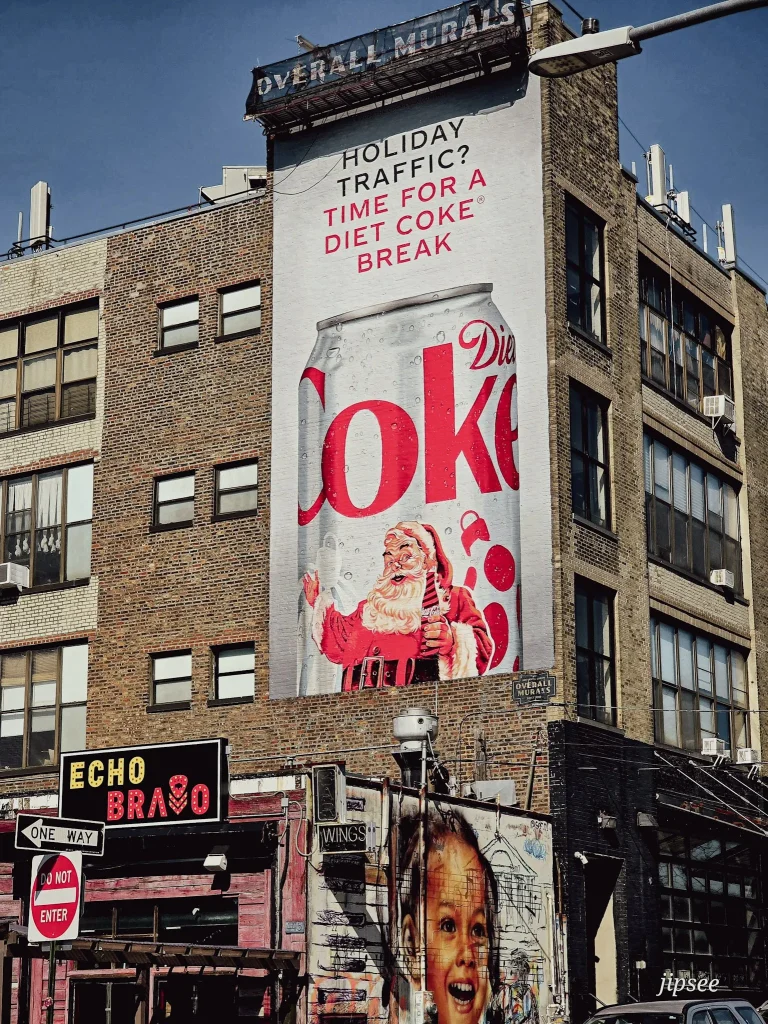 pub geante coca cola sur un mur de brique street art et boutique dans la rue