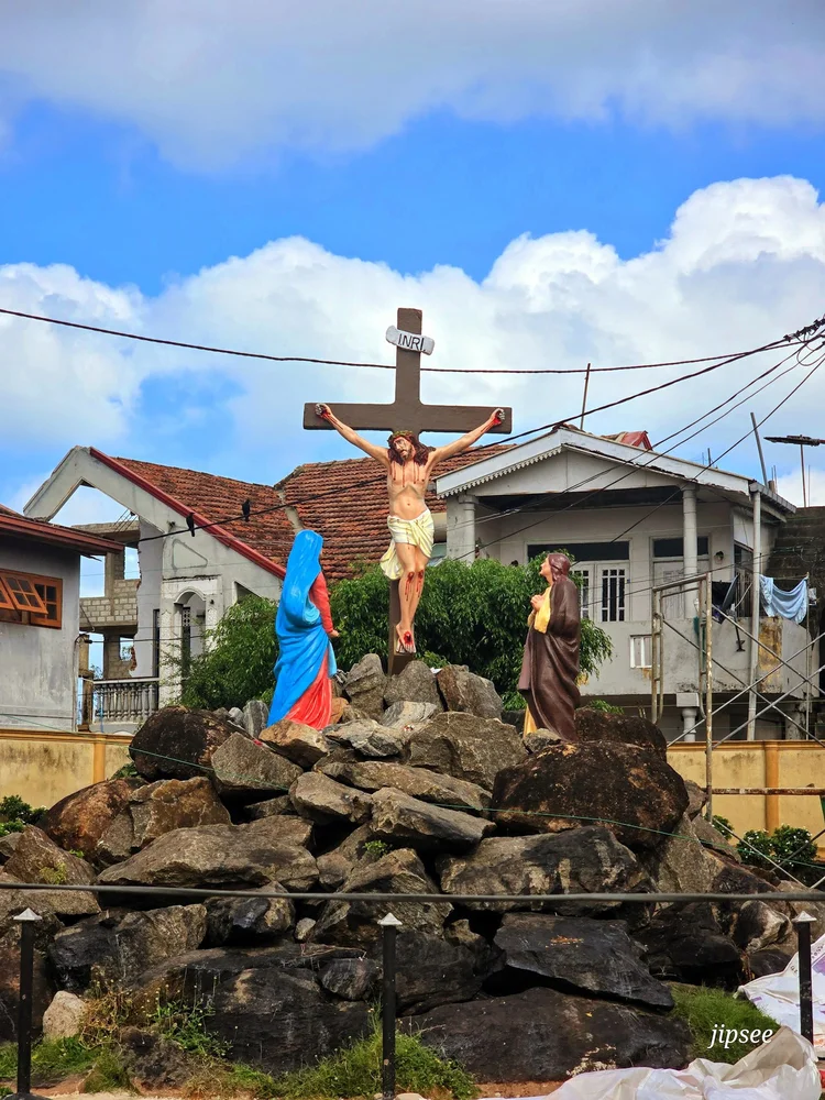 scene chretienne jesus sur la croix sur un tas de rochers devant des maisons