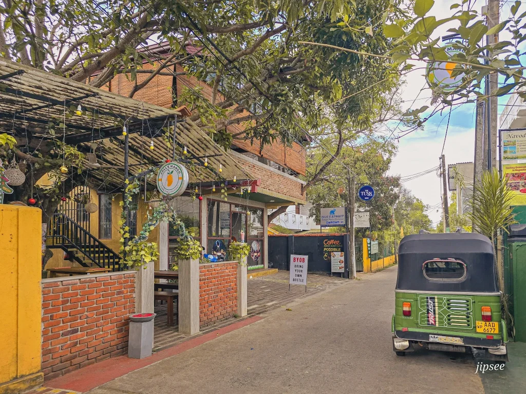 devanture restaurant jolly mango tuk tuk vert garé devant dans une rue du sri lanka