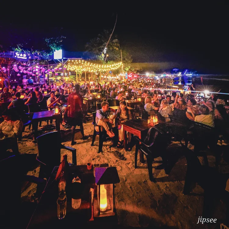 terrasse de restaurant sur la plage la nuit bondée de monde