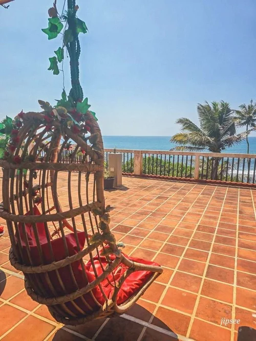 chaise suspendue en rotin avec une vue sur la mer 