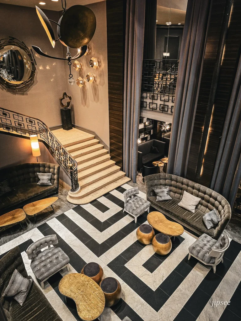 hall avec escalier canape et grands rideaux gris