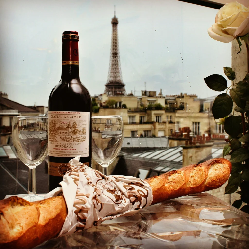 bouteille de vin rouge et baguette de pain servi devant la tour eiffel