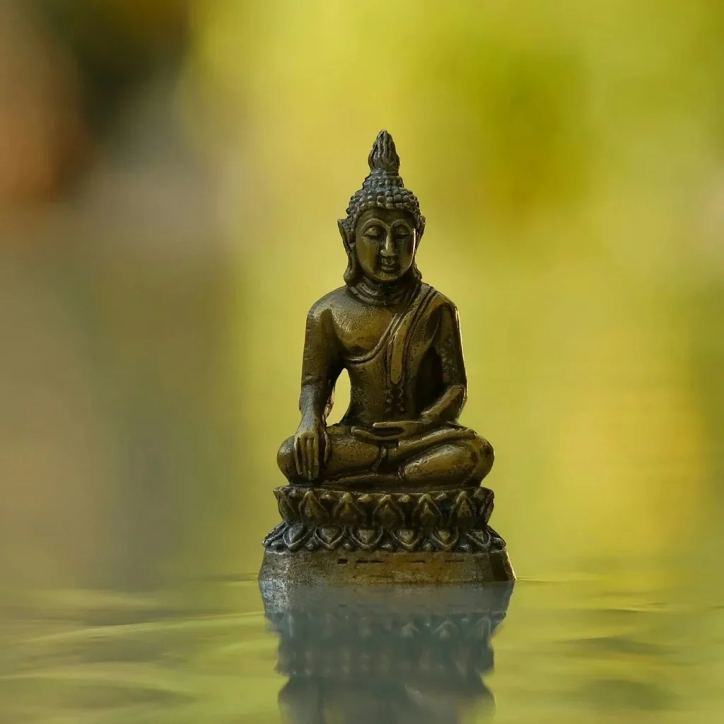 sculpture de bouddha miniature sur un fond vert 