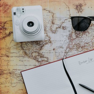 carnet ouvert sur un titre bucket list posé sur une map du monde