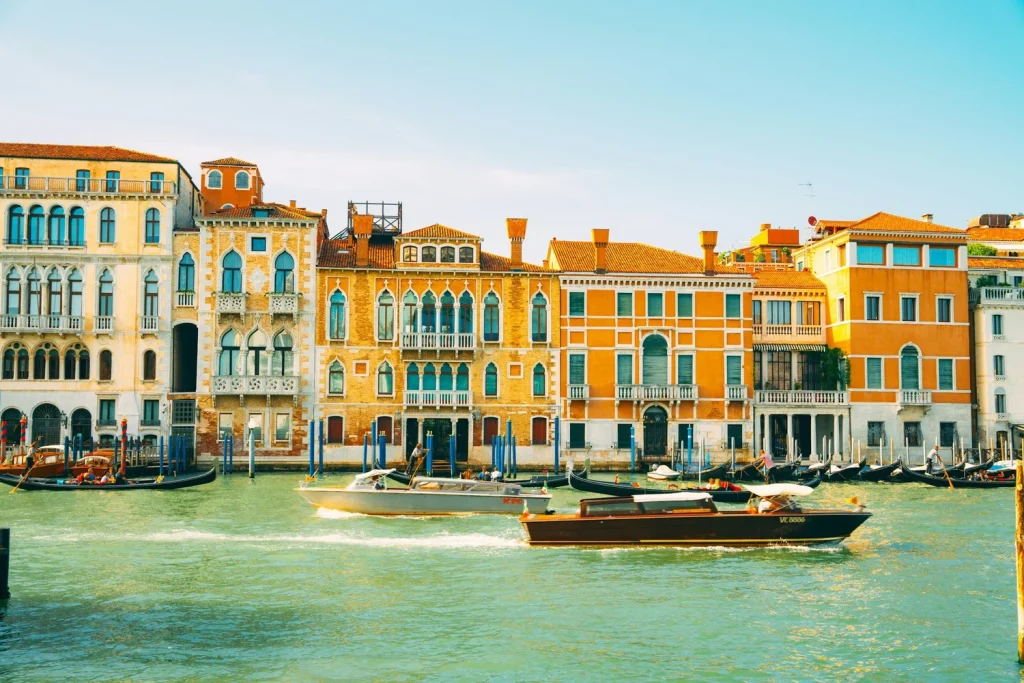 plusieurs bateaux voguant sur le grand canal de venise facades dorées typiques en fond