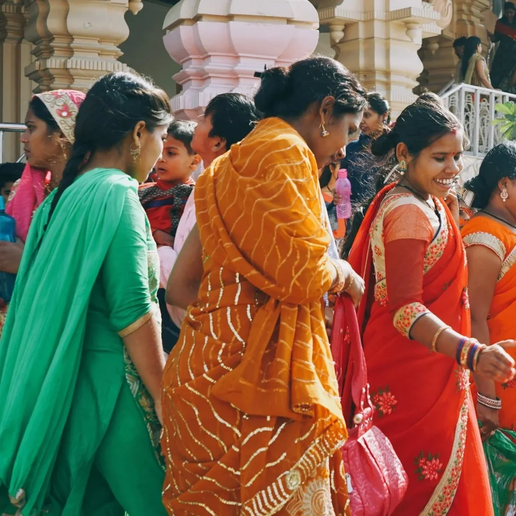 groupe de femmes souriantes vetues de sari traditionels colorés