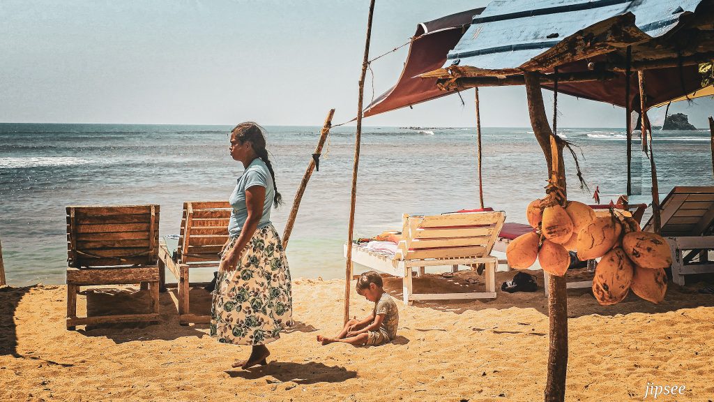 femme marchant sur la plage de galle au sri lanka enfant jouant dans le sable