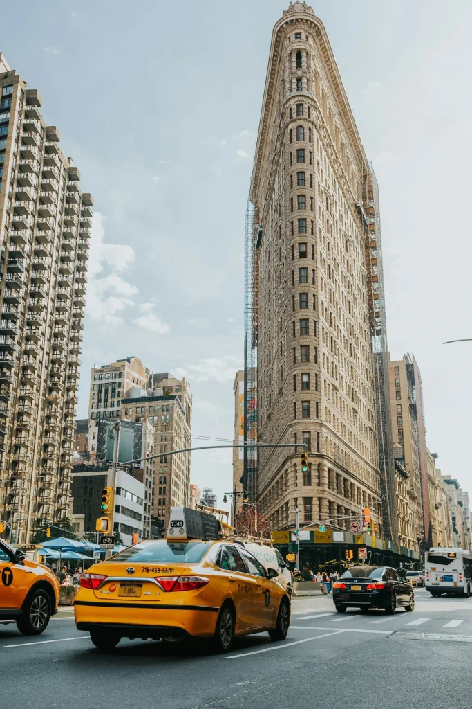 taxi jaune roulant devant le flariton building