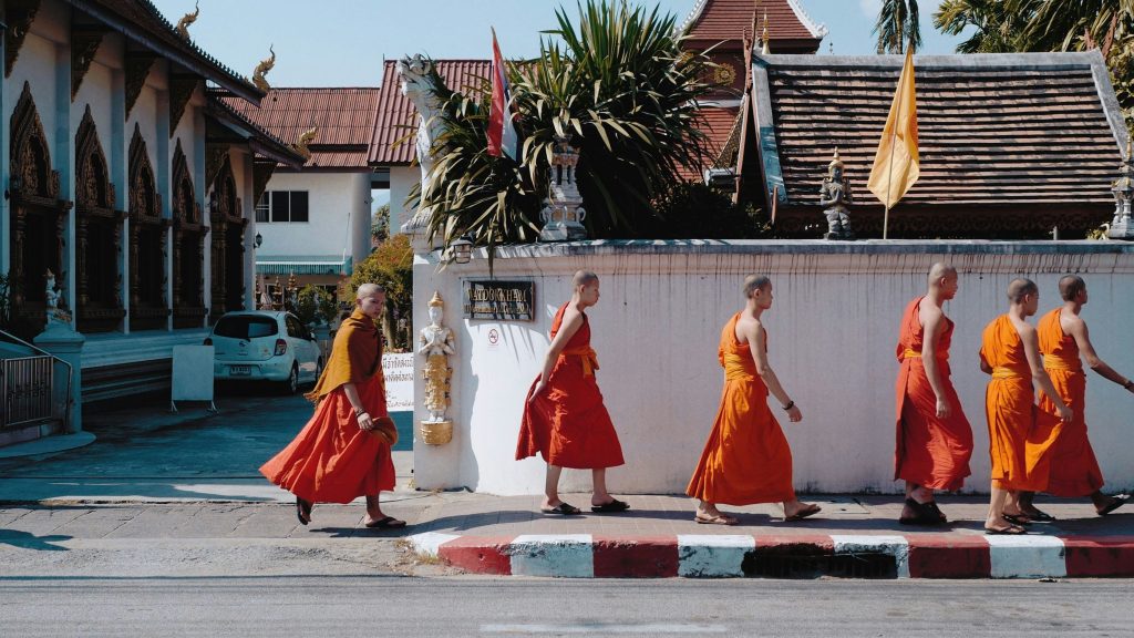 six moines en tenue traditionnelle marchant dans les rues de chiang mai en thailande