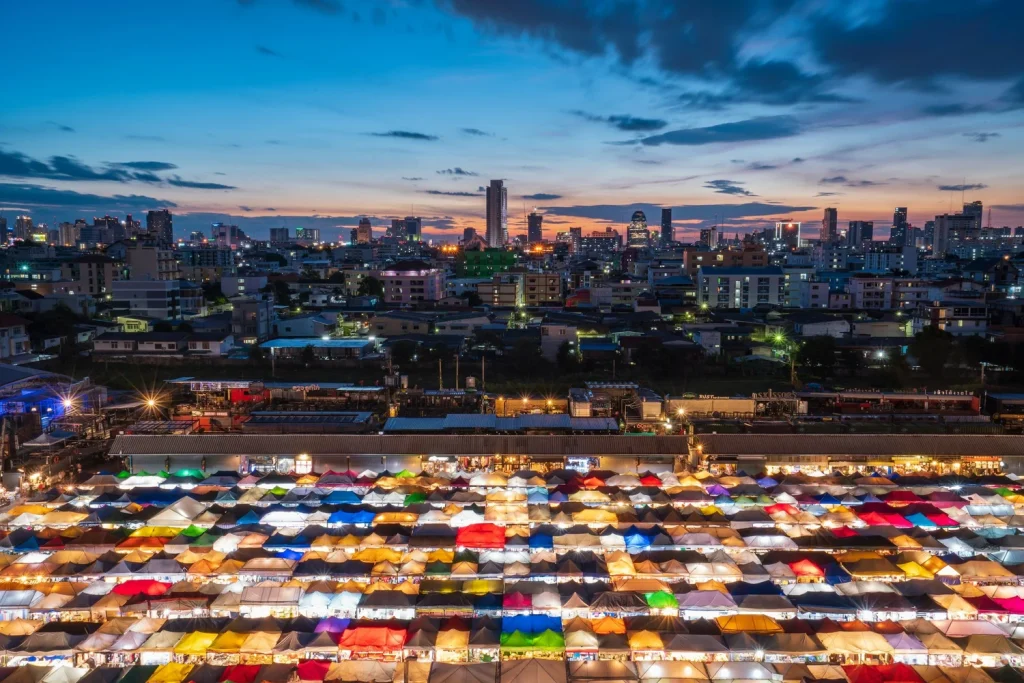 les toits illuminés d'un night market de bangkok les building modernes en fond