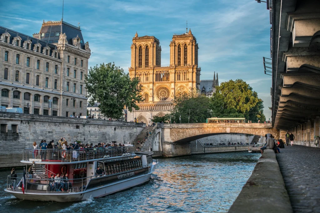 bateau mouche voguant sur la seine au pied de notre dame de paris