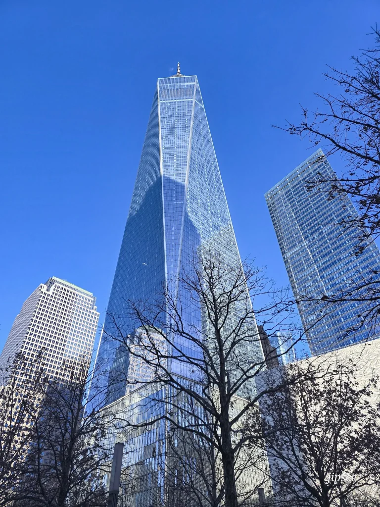 le gratte ciel vitré du one world trade center vu d'en bas sous un ciel bleu