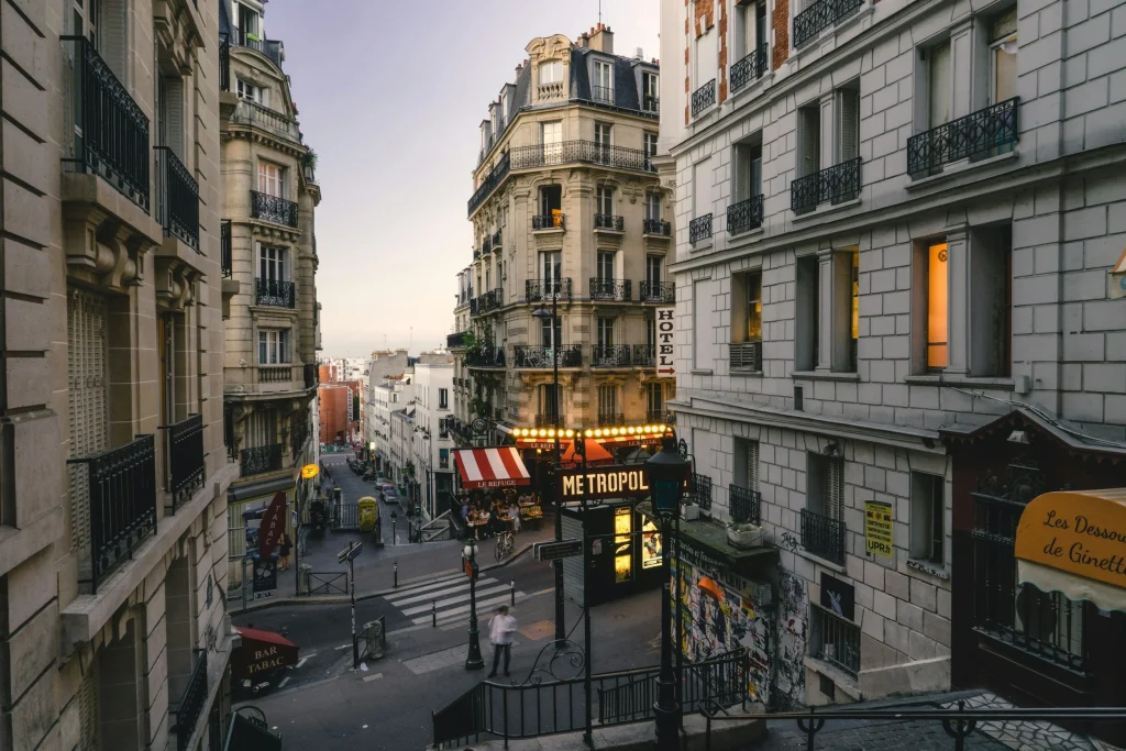 rue de paris au sunset enseigne de restaurant illuminée escaliers typiques et architecture 