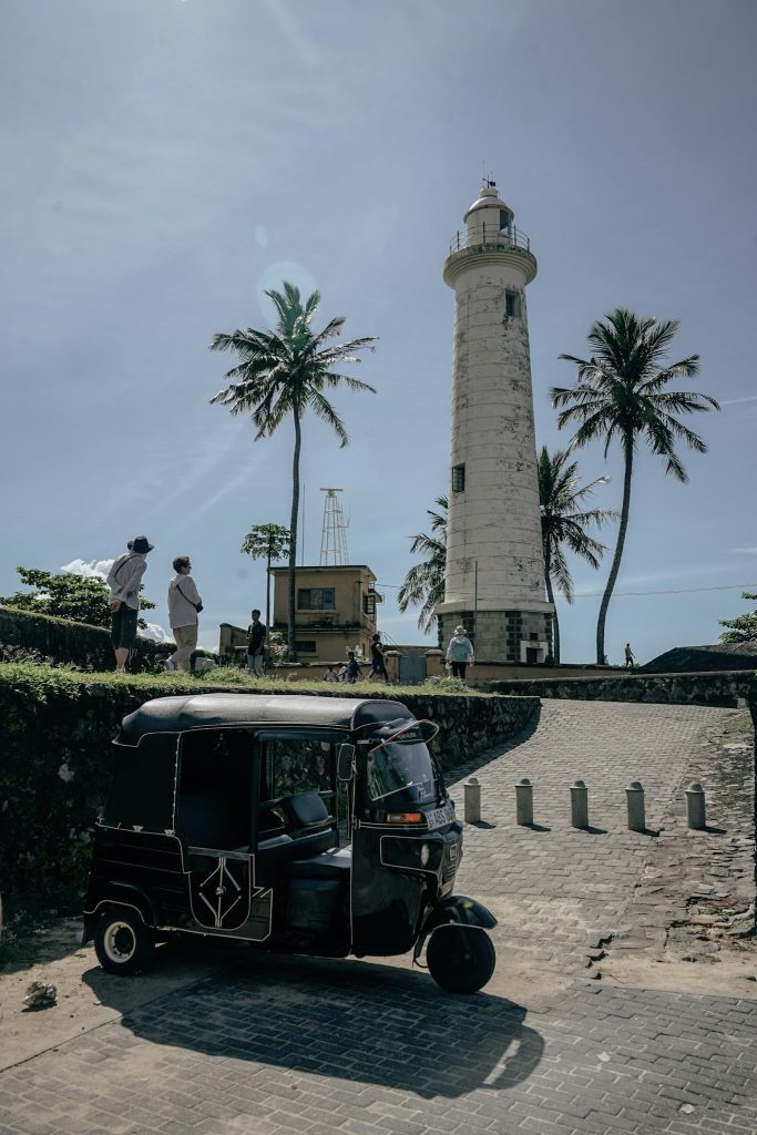 phare blanc du centre historique de galle et tuk tuk devant