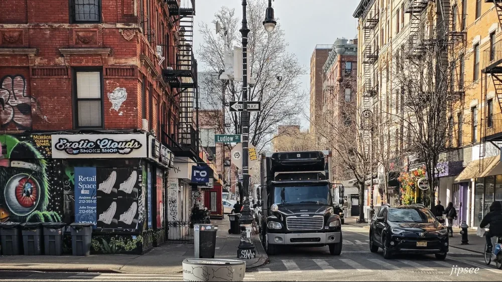 camion dans une rue animée de boutique brique rouge et escalier typique de new york