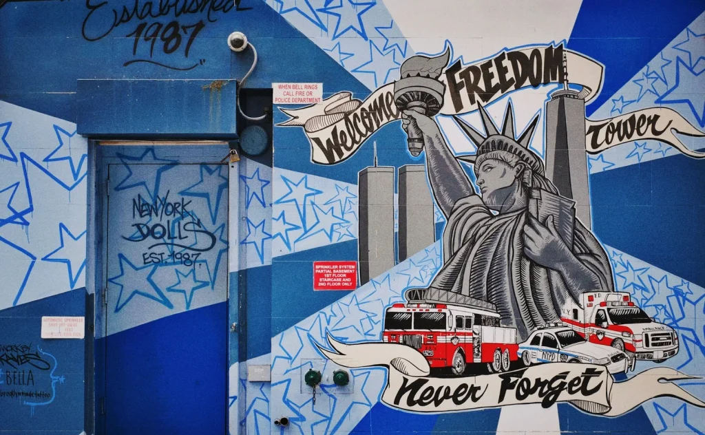 street art sur un mur bleu statue de la liberté welcom fredom never forget