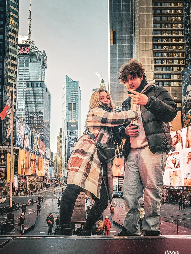 un homme et une femme sur les marches de time square debout en train de chahuter
