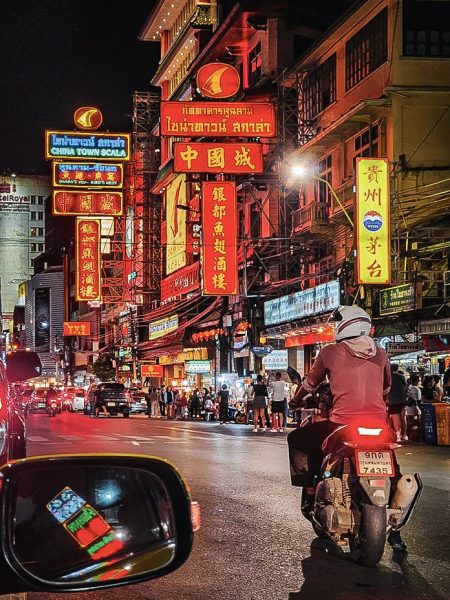 moto devant les neons de chinatown bangkok illuminés