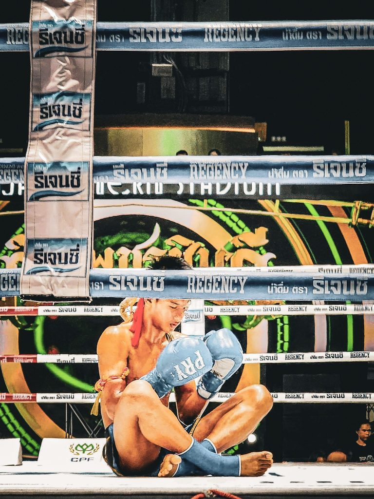 jeune boxeur thailandais assis sur le ring lors d'un match a bangkok