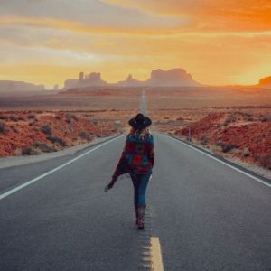 femme de dos face a un desert sur une route