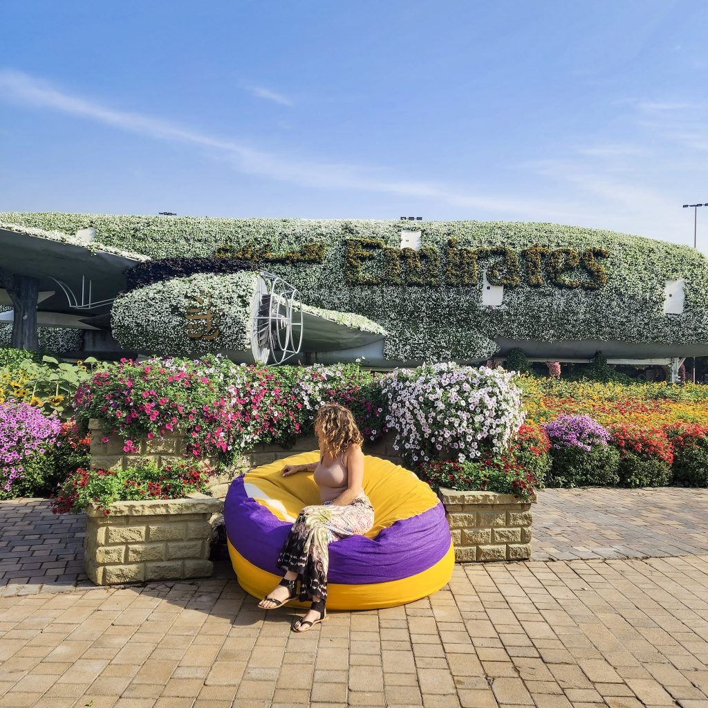 femme assise sur un pouf devant l'avion A380 emirates du dubai miracle garden
