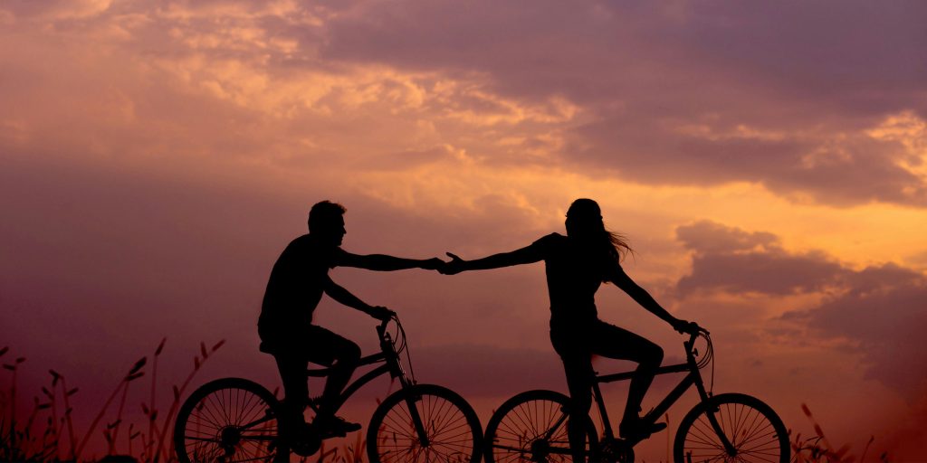 couple au coucher du soleil en train de faire du velo