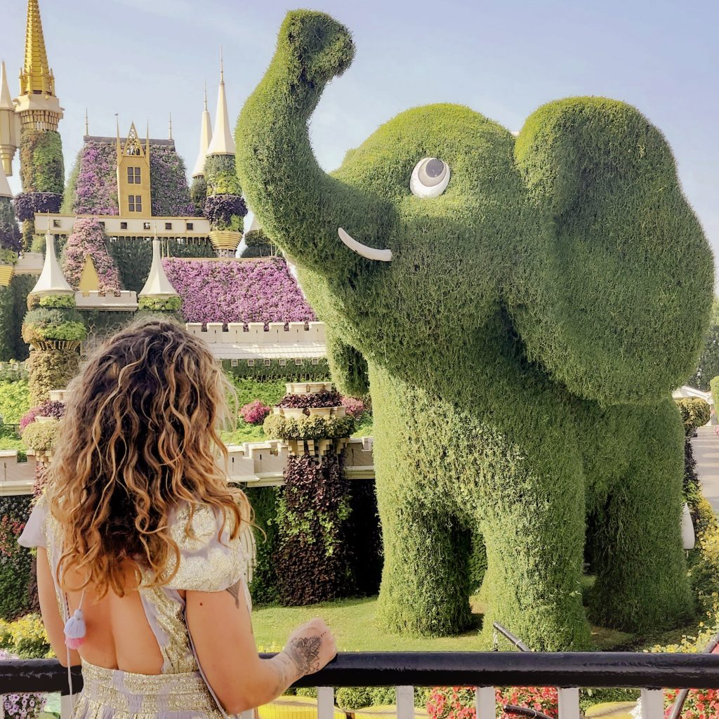 femme de dos devant un elephant vegetal au dubai miracle garden