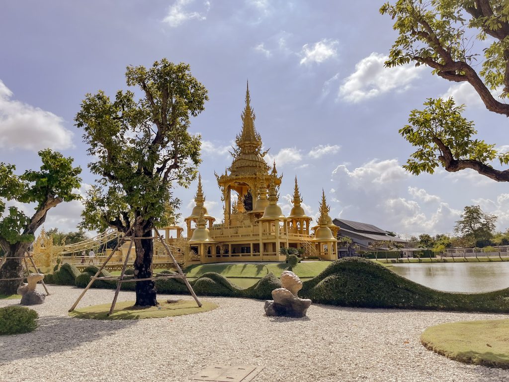 pavillon dore au bord du lac dans l'enceinte du temple blanc de chiang rai