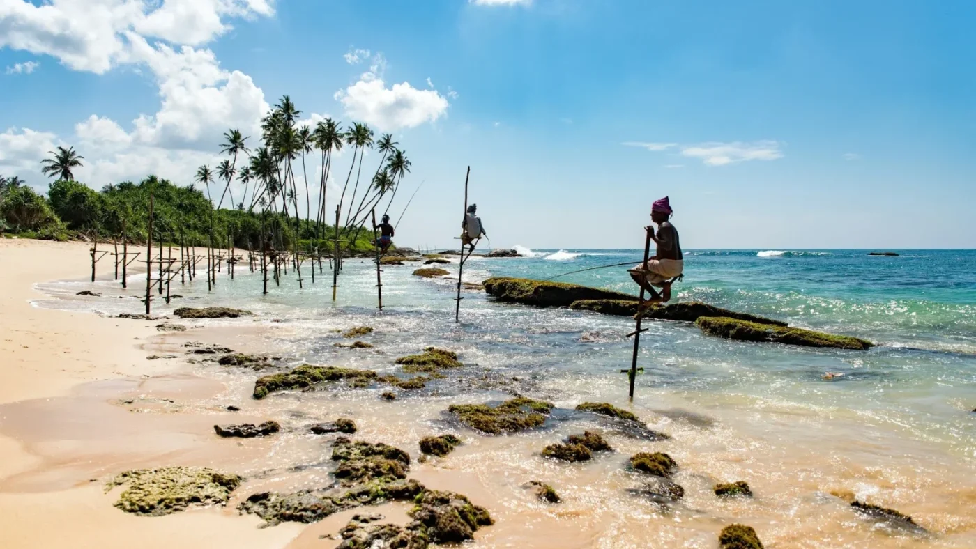 pecheurs sur echasses en bord d'ocean indien sur une plage du sri lanka
