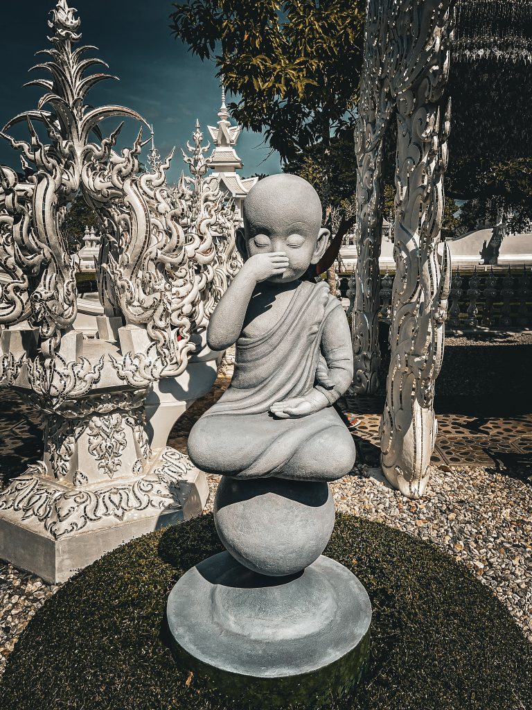 sculpture de bouddha se couvrant la bouche