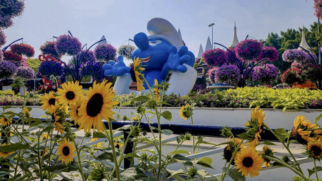 schtroumpfs geant derriere un parterre de tournesol au dubai miracle garden