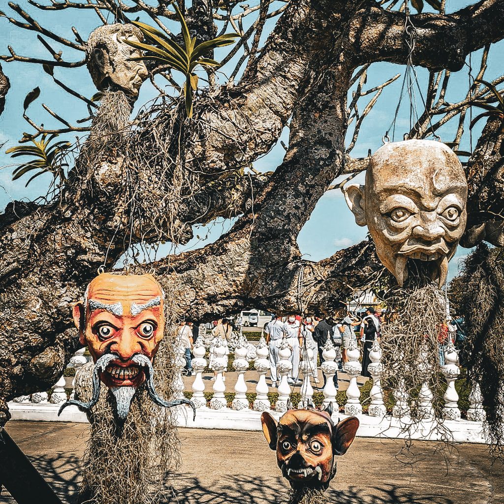 sculpture decalée dans les arbres du temple blanc de chiang rai en thailande